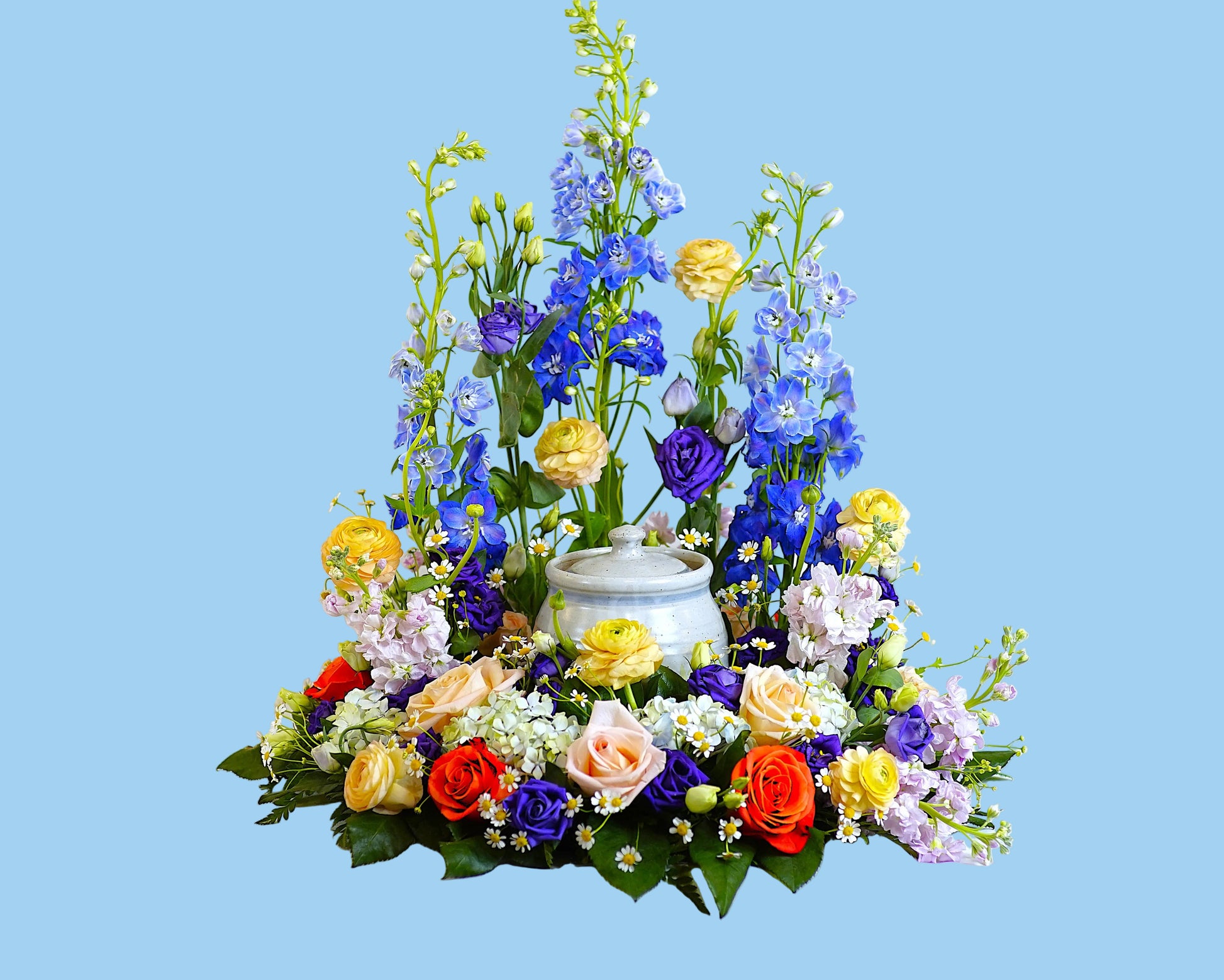 Colorful flower arrangement with a teapot on a white background