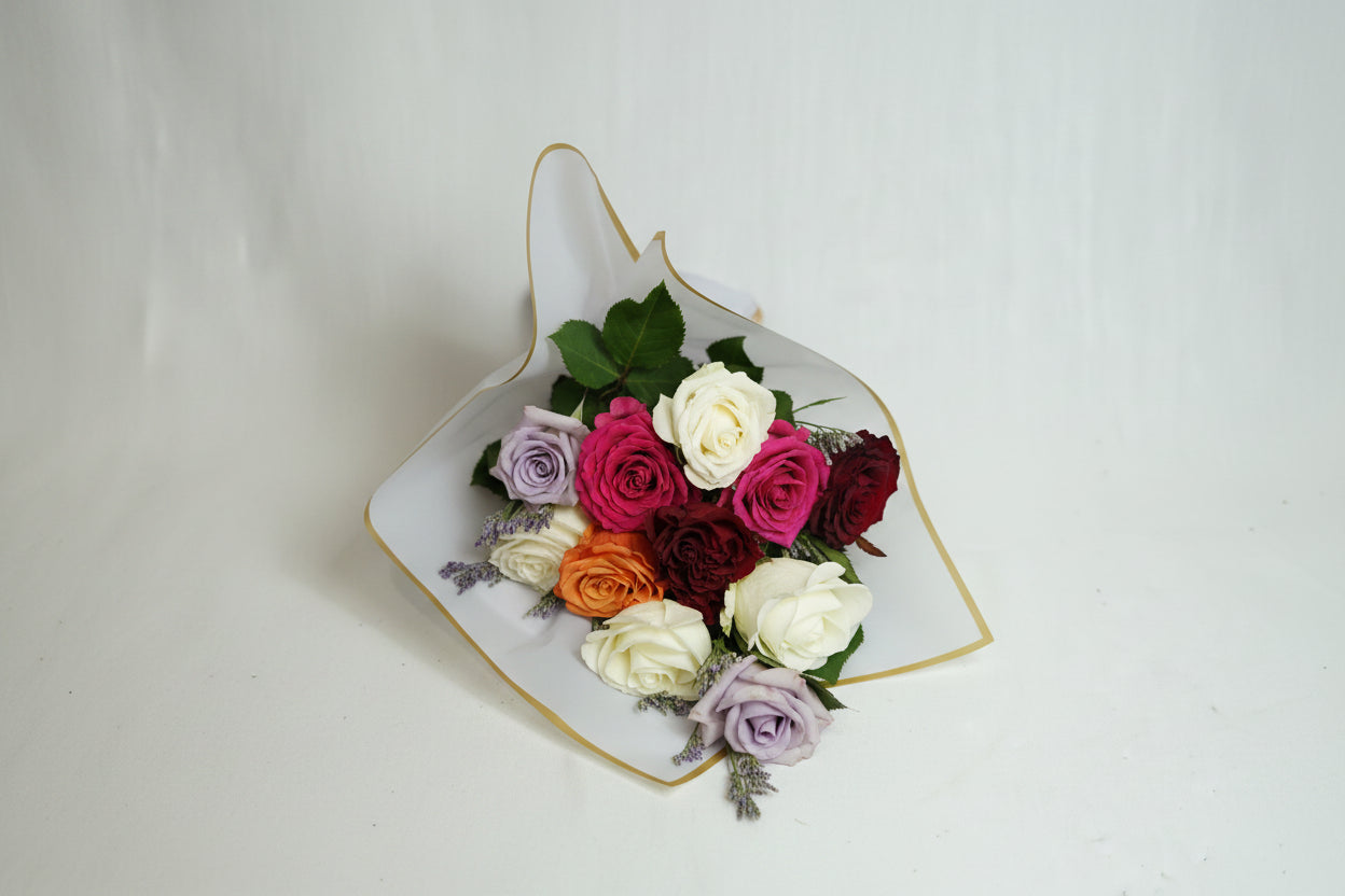 Colorful bouquet of flowers in a decorative paper cone on a white background